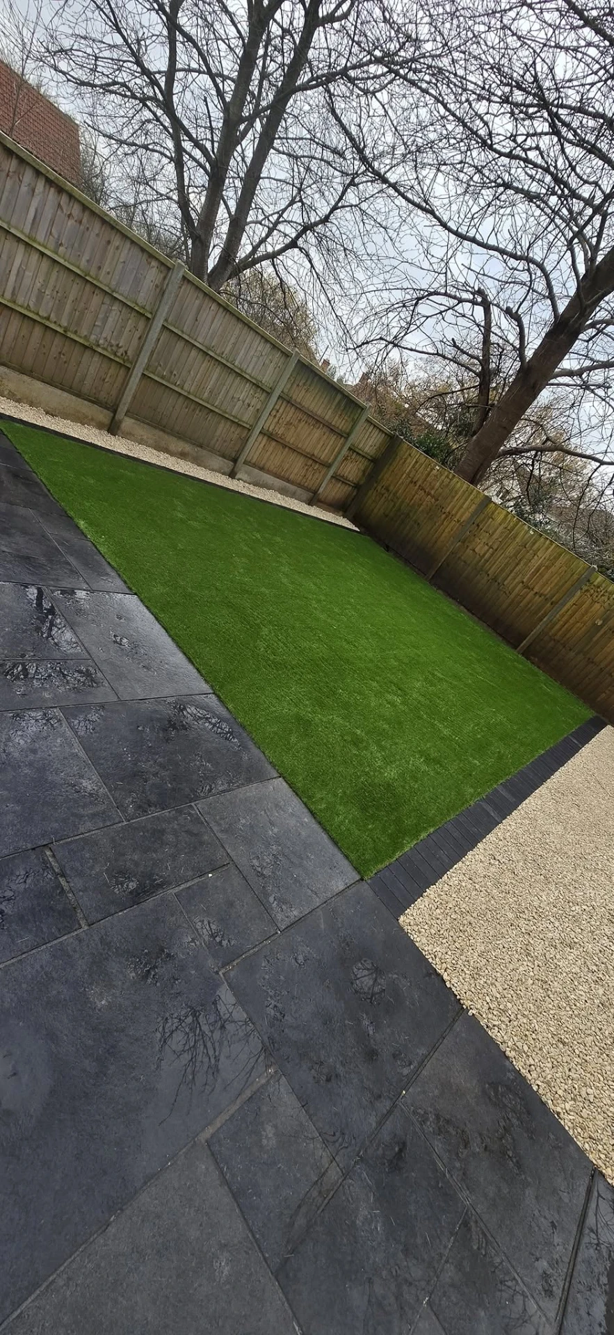 Charcoal slate patio with a fresh strip of artificial lawn